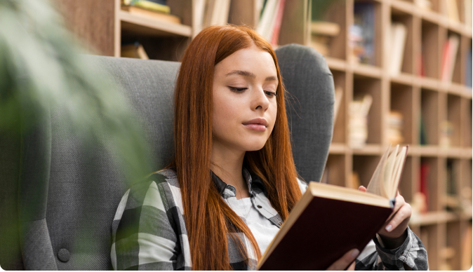 Woman reading a book in a library setting